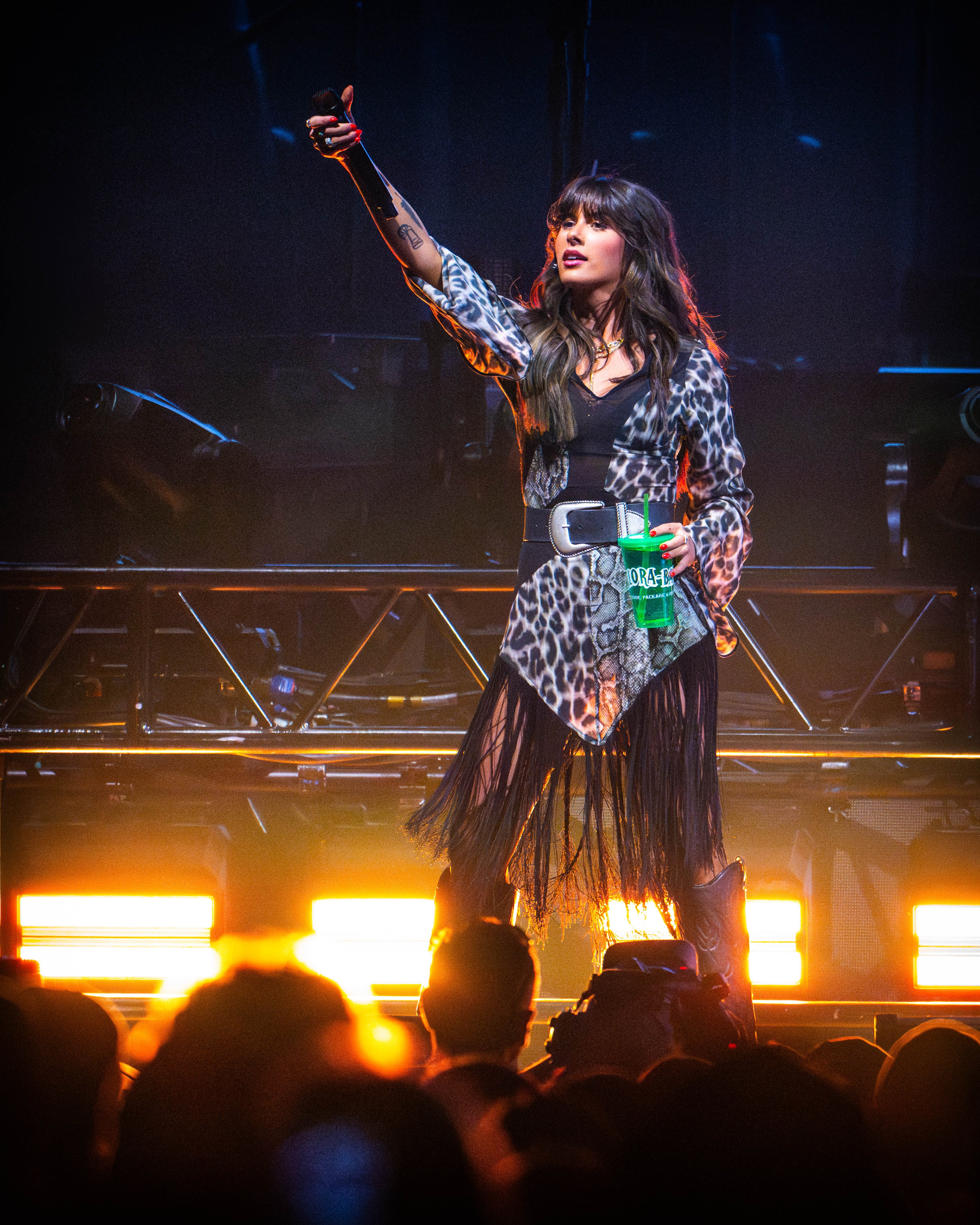 Ella Langley performing in a silver leopard bodysuit with long dark fringe